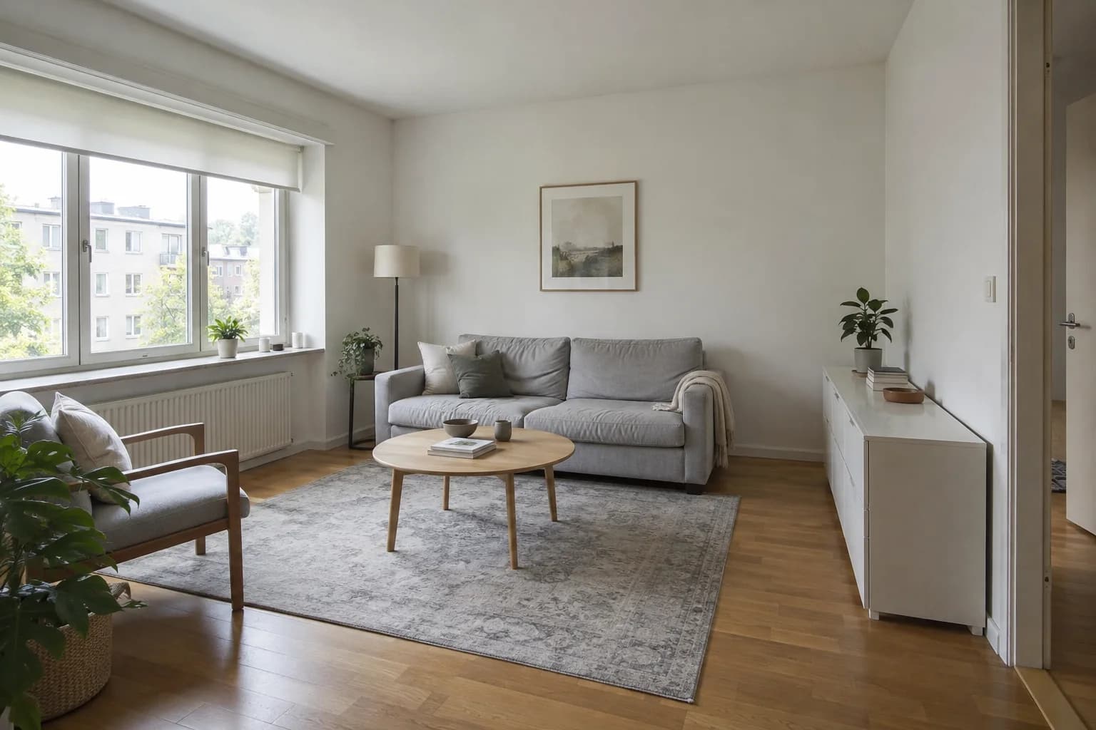 Starting room: a grey sofa, white sideboard and oak floor in a daylight apartment